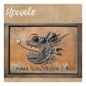 Art work: a fish made out of up-cycled metal items, on a wood base.