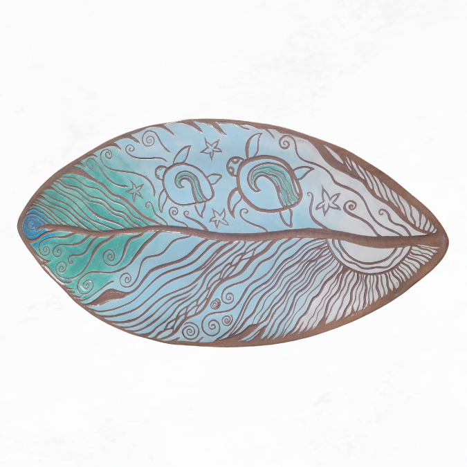 Ceramic large feather, ocean theme with two turtles, star fish, wavy lines of water, and sun. Colours, brown clay with white, light blue and turquoise colouring.