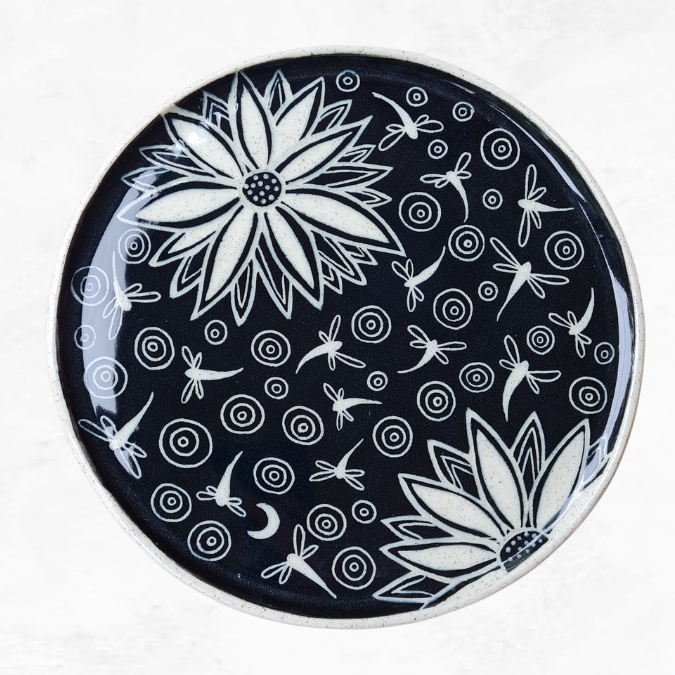 Ceramic large plate, decorated with two large flowers many dragonflies, and circle ripples, black and white in colour.